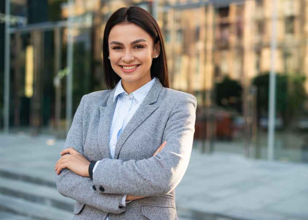 smiley businesswoman posing outdoors with arms crossed copy space 11zon